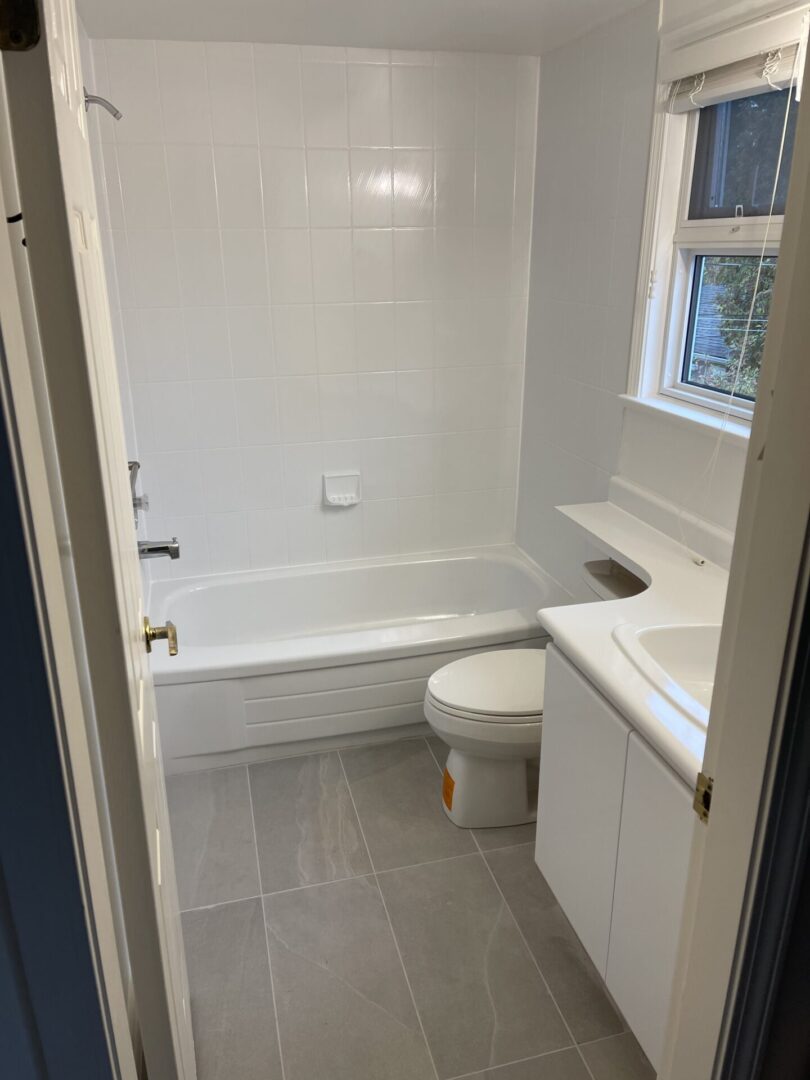 A picture of a bathroom with white tiles