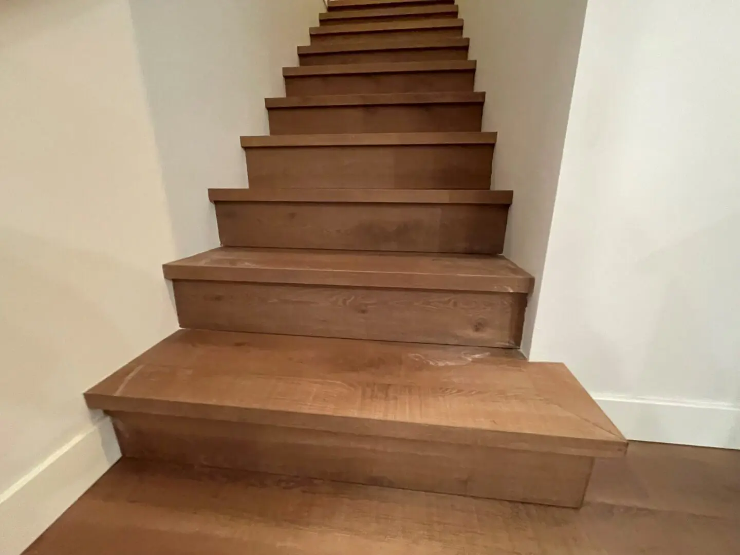A picture of a brown color stairs build inside the house